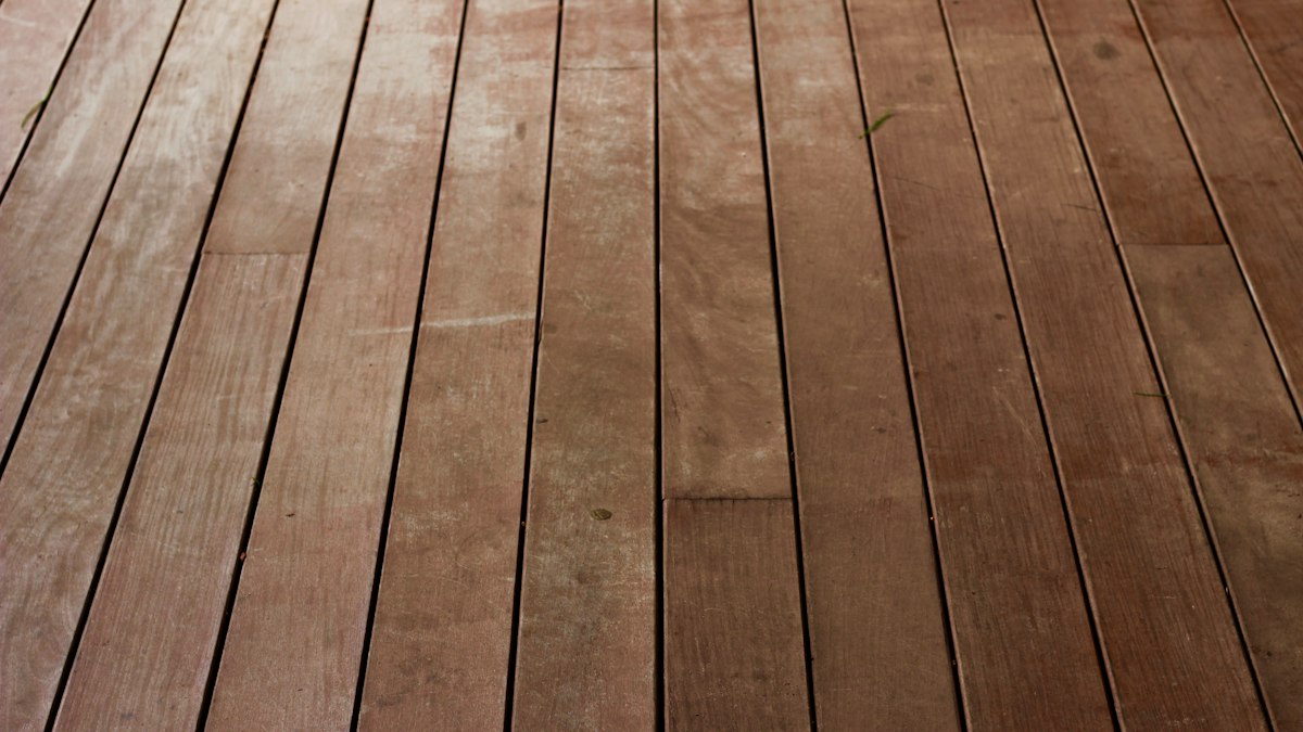 Artisan vitrifiant un parquet en chêne dans un appartement